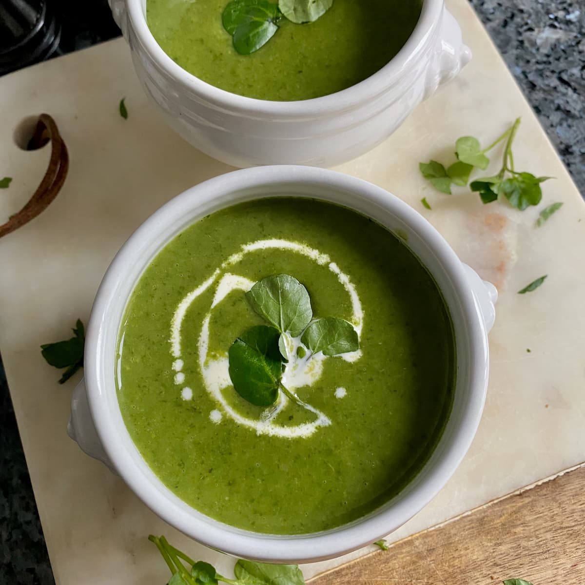 Watercress soup with a mini herb macaron French lion bowl of bright green watercress soup