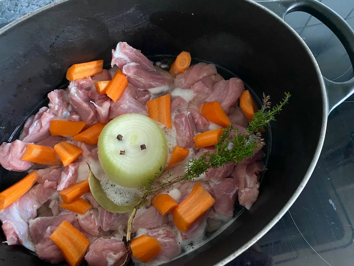 blanquette-de-veau French veal pot casserole meat, carrots and onion studded with cloves in a big black pot