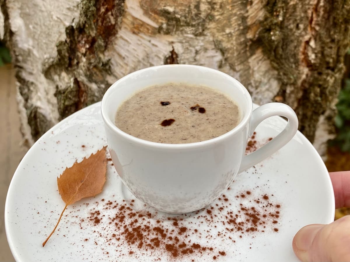 cup and saucer of mushroom soup dusted with cocoa powder