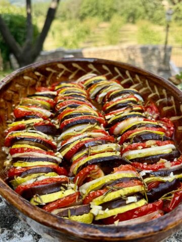 French baking dish of sliced roasted summer vegetables
