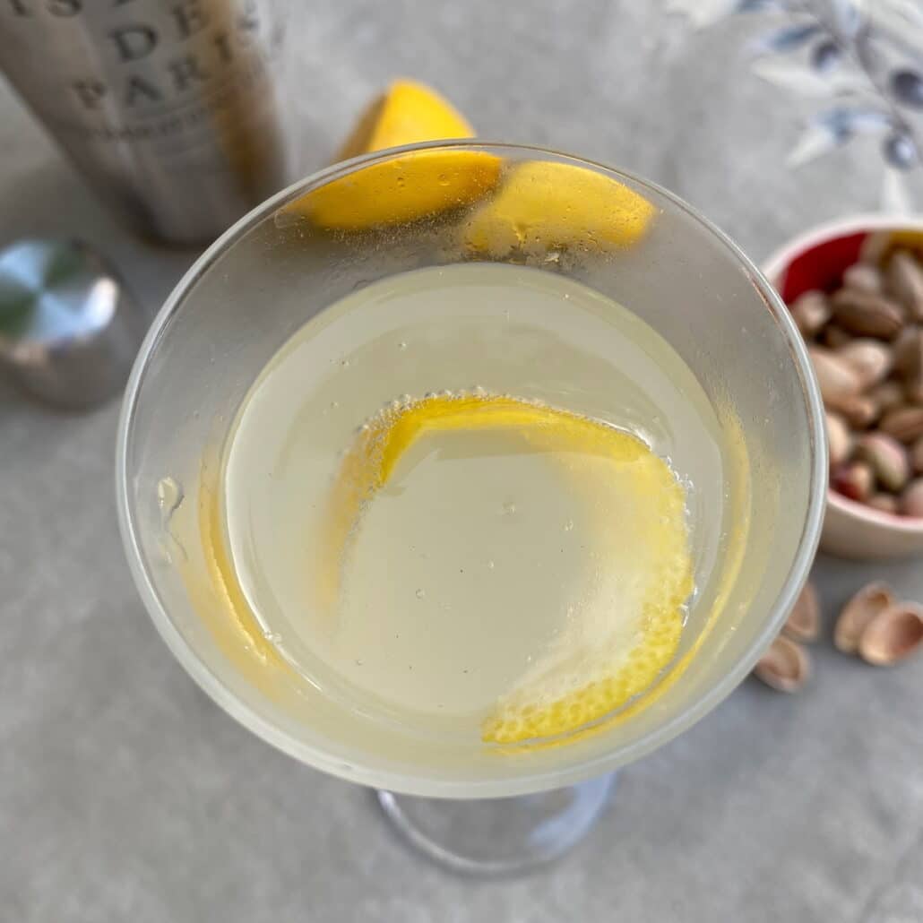 lemon twist garnish in a Champagne glass filled with a French 75 cocktail