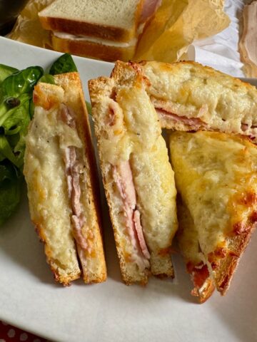 cheese and ham hot sandwich, sliced in half to see the soft insides and toasted texture on top